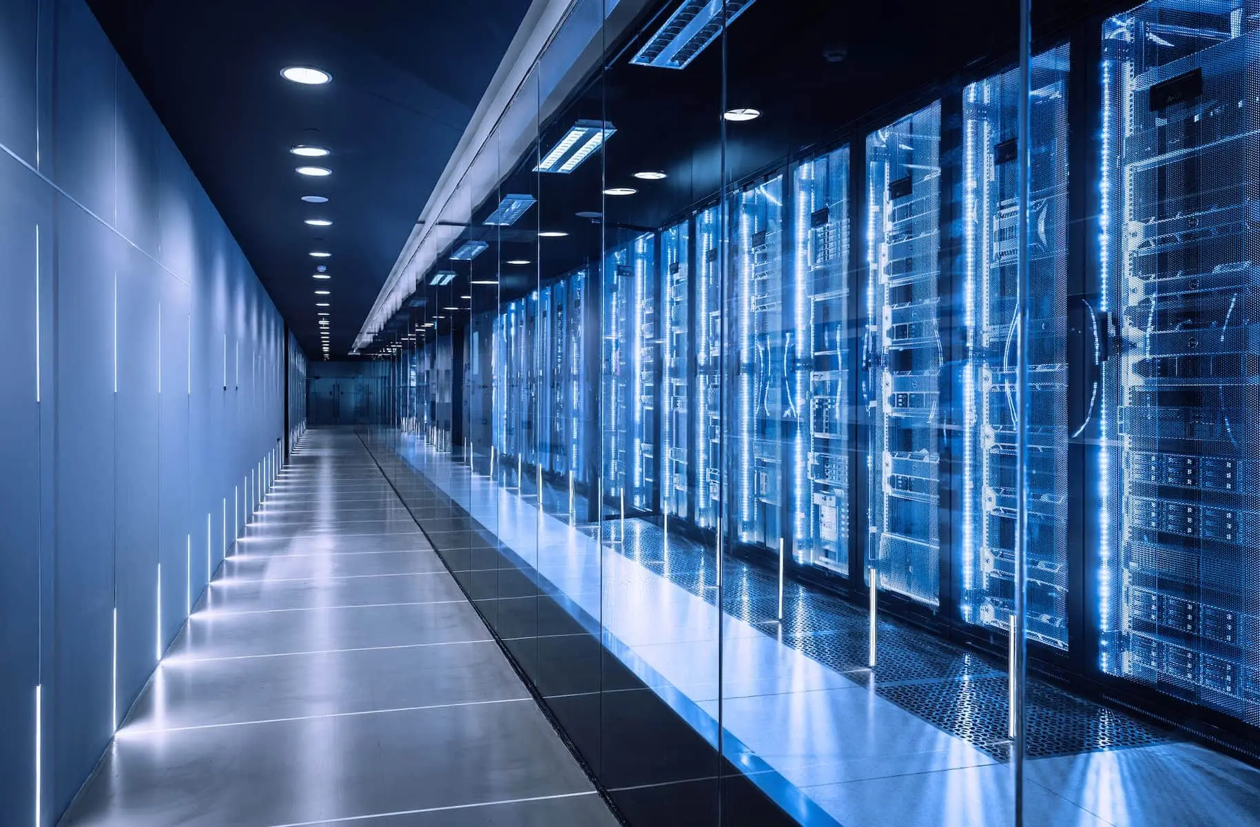 A long row of glowing blue server racks in a modern, high-tech data center corridor