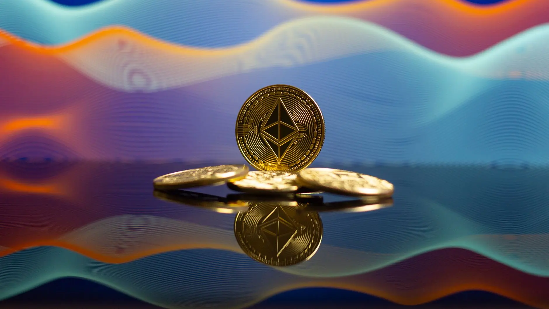 Gold Ethereum coins resting on a reflective surface with a colorful abstract wave background