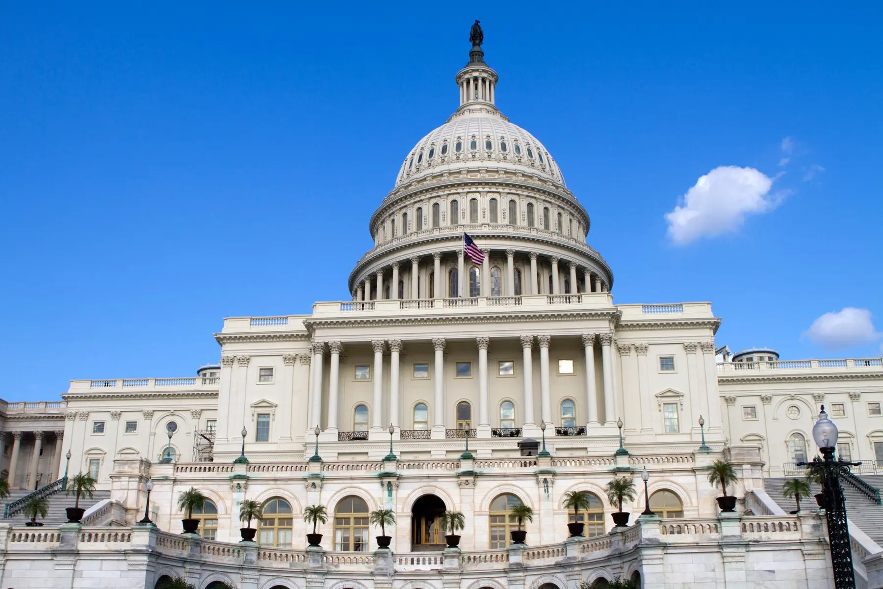 Exterior view of the white dome and neoclassical architecture of the US Capitol building in Washington DC