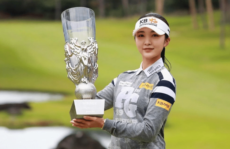 Golfer Lee Ye-won holds a golf trophy. 
