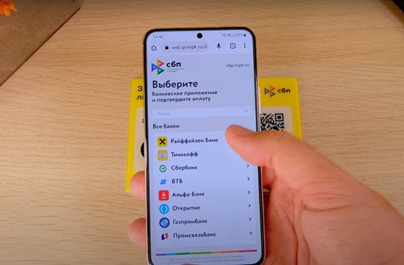 يد تمسك هاتفاً عليه تطبيق SBP