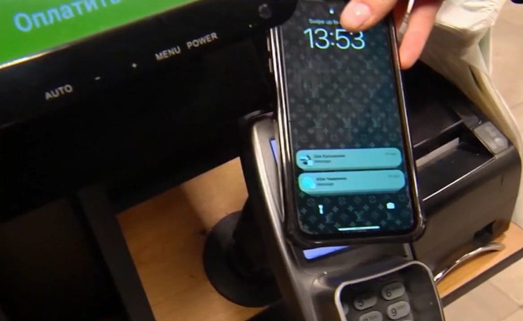 A customer uses their mobile phone to pay in a Russian store.