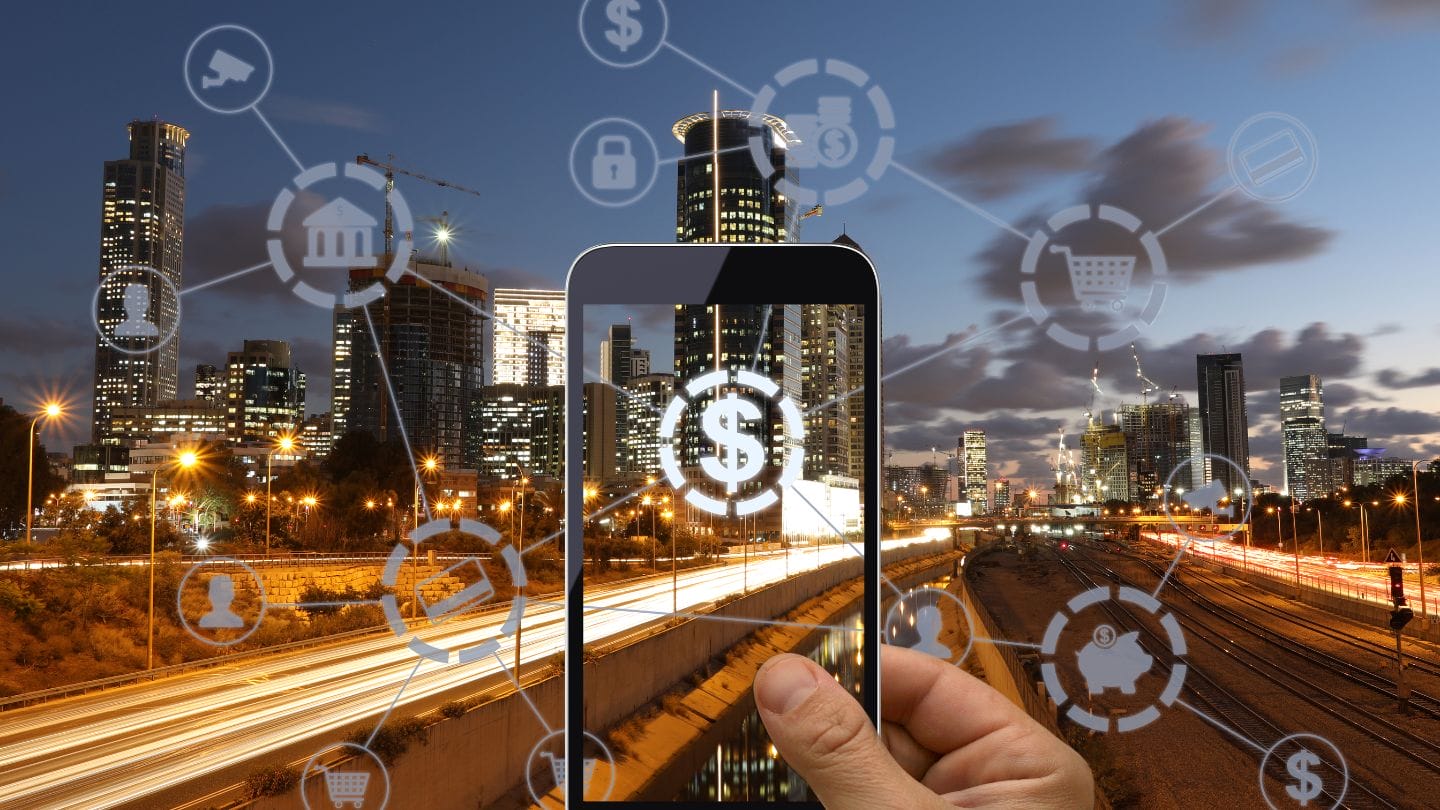 Tokenisaatio on nyt kaikkien huulilla rahoitusalalla. Kuvituskuvassa suurkaupunki älypuhelimen läpi katsottuna.