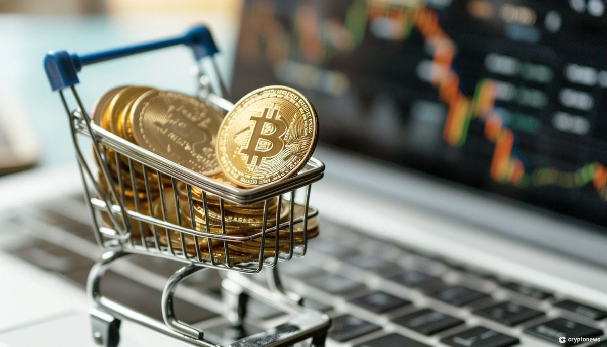 Kryptomaksut kuvituskuvassa ostoskärry läppärin päällä täynnä bitcoineja.