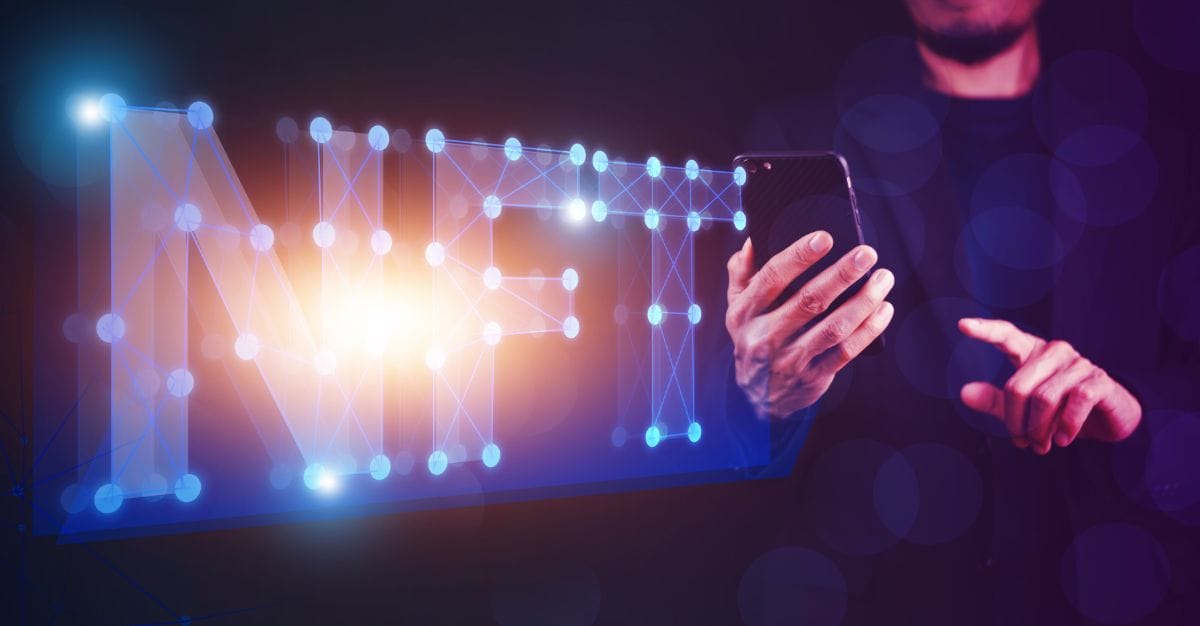 光るNFTという文字とスマホを操作する男性