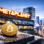A Bitcoin coin sits on a snowy ledge overlooking Metaplanet’s Tokyo headquarters, highlighting the company’s stalled BTC purchases over the past three months.