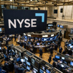 Traders work beneath a NYSE banner on the exchange floor, signaling a new blockchain system using stablecoins to process dividends inside Wall Street plumbing