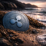 Ripple’s XRP coin resting on a rocky shoreline as waves recede, symbolizing market pessimism and the case that XRP may be undervalued despite fading sentiment
