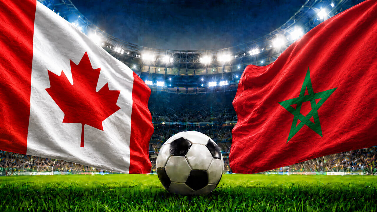 Canada and Morocco flags face off above a soccer ball in a packed stadium, representing a FIFA World Cup prediction market matchup.