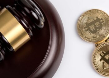 Picture of a gavel and sound block with three bitcoins right next to it