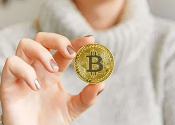 Picture of a hand holding a bitcoin