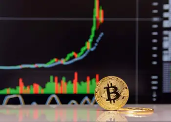 Picture of a bitcoin standing in front of a chart in an upward trend