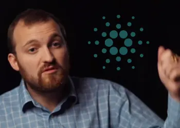 Picture of Cardano co-founder Charles Hoskinson with a Cardano logo behind him on a black background