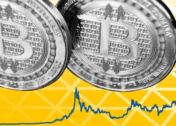 Picture of two silver bitcoins next together, with an upward trend line next to it