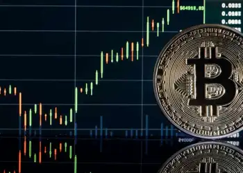 Picture of a bitcoin in front of a market chart